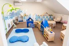 Sala z niebieskimi domkami, poduszkami i zabawkami sensorycznymi